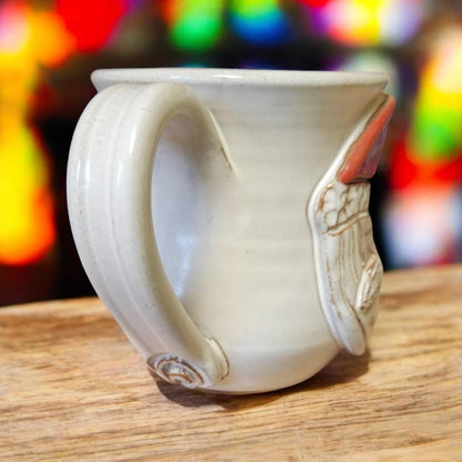 White ceramic mug with a handle on a wooden surface with a colorful blurred background