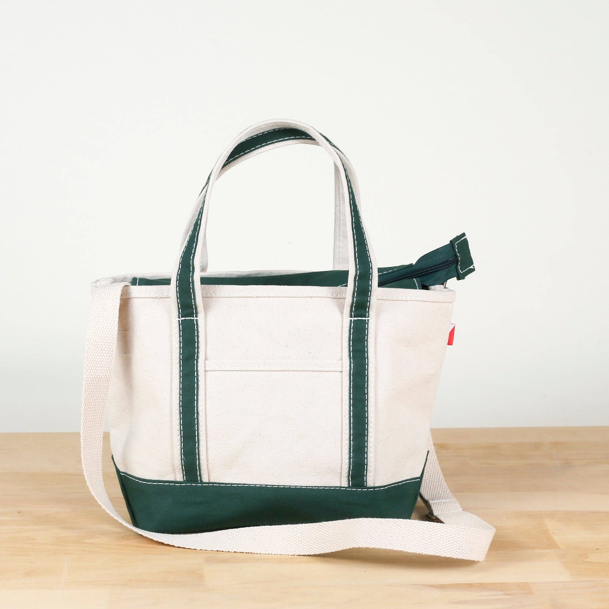 White tote bag with green accents on a wooden surface