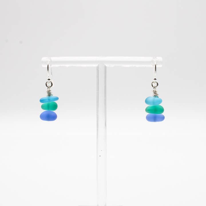 Pair of earrings with blue and green beads on a white background