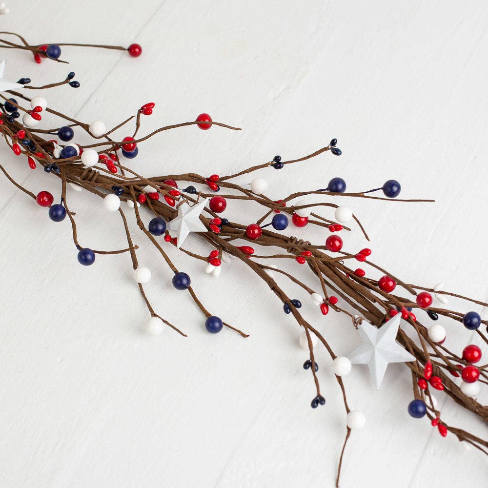 Decorative branch with red, blue, and white berries on a white background