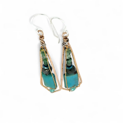 Turquoise stone earrings with gold and silver wirework on a white background