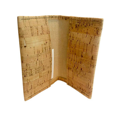 A cork wallet shown open, displaying its natural cork exterior with a textured grain pattern and a beige fabric interior lining.
