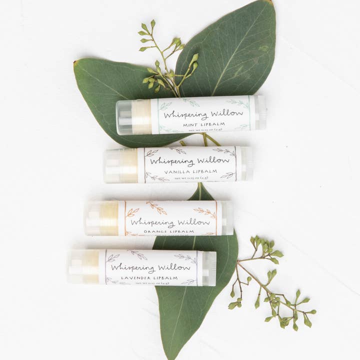 Set of lip balms labeled 'Whispering Willow' with green leaves on a white background