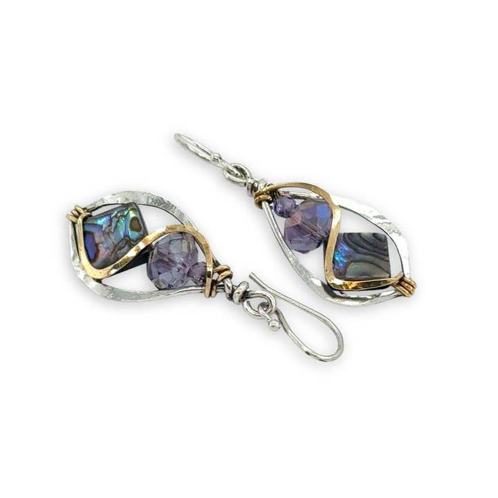 Pair of earrings with purple gemstones and gold accents on a white background