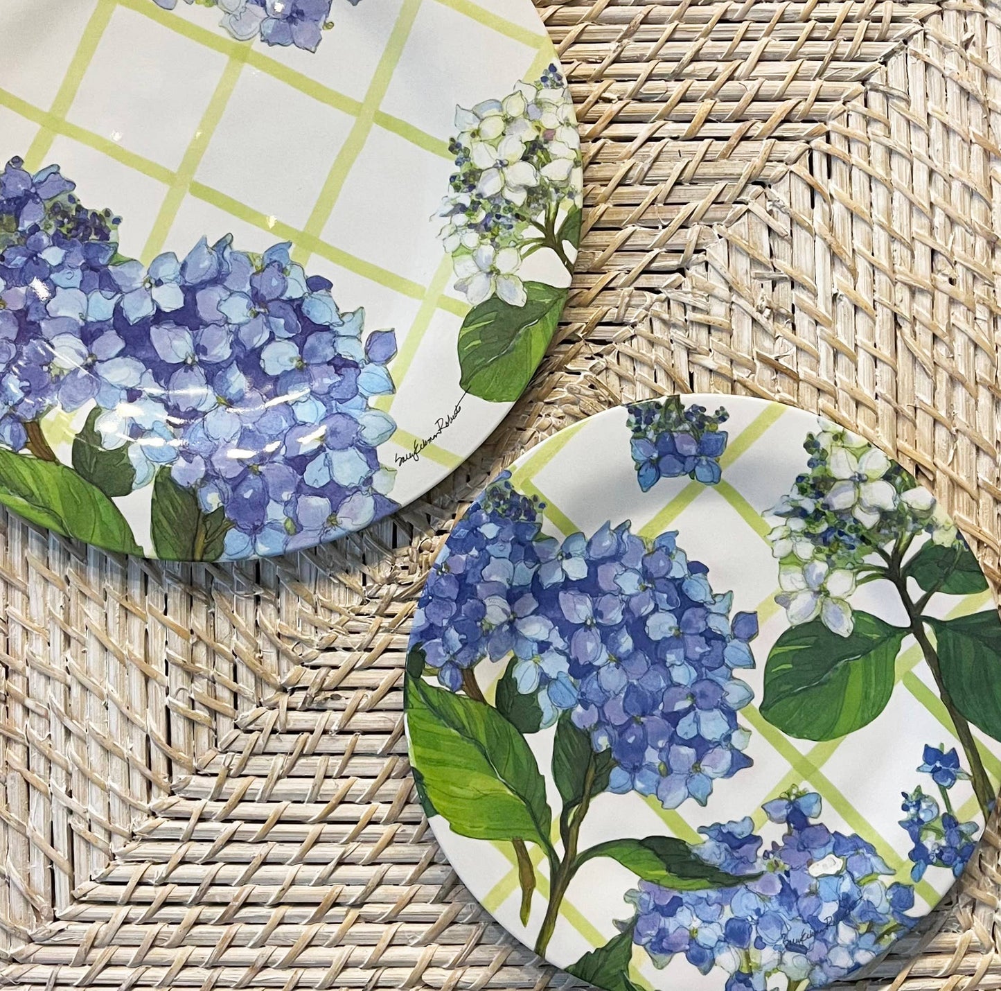Two plates with blue floral design on a woven surface