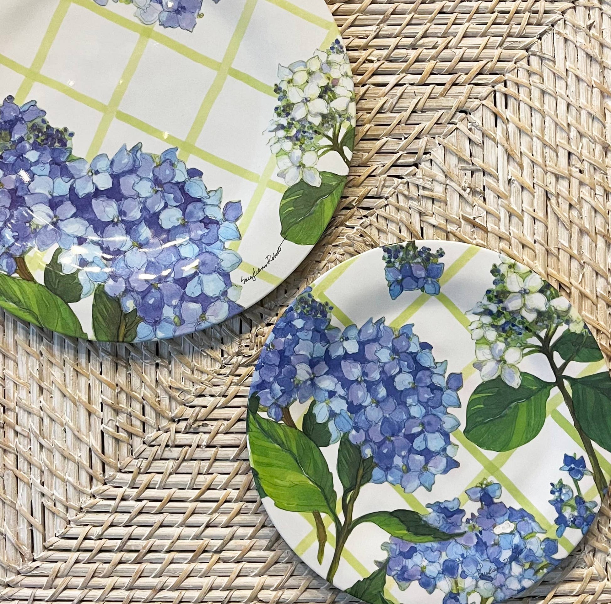 Two plates with blue floral design on a woven surface