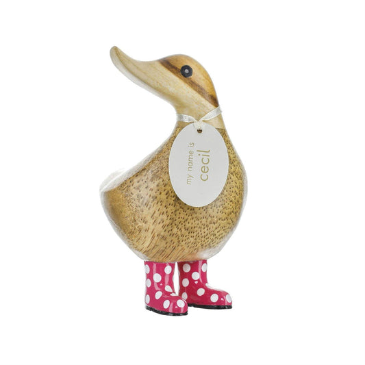 Wooden duck figurine with a tag and pink polka dot boots on a white background