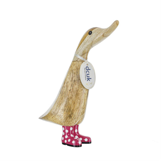 Wooden duck figurine with pink polka dot boots on a white background
