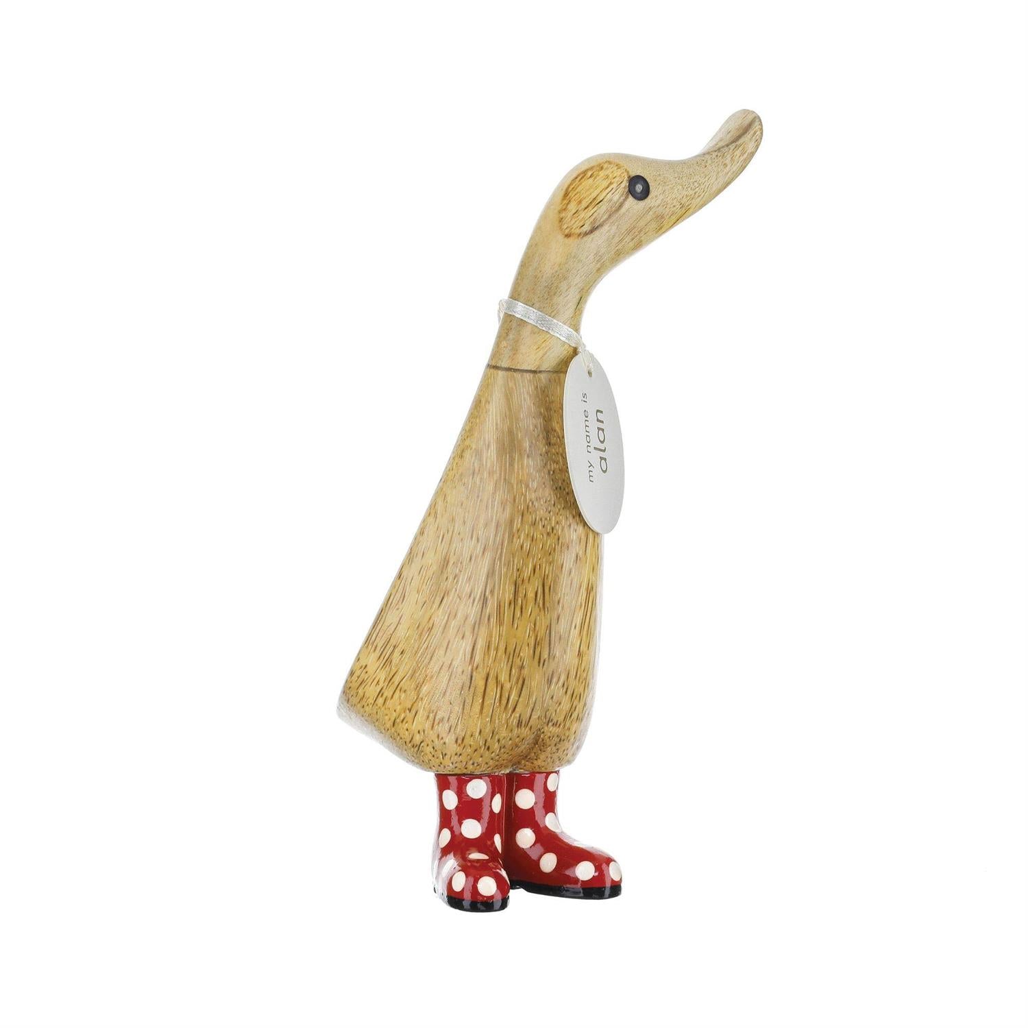Wooden duck figurine with red polka dot boots on a white background