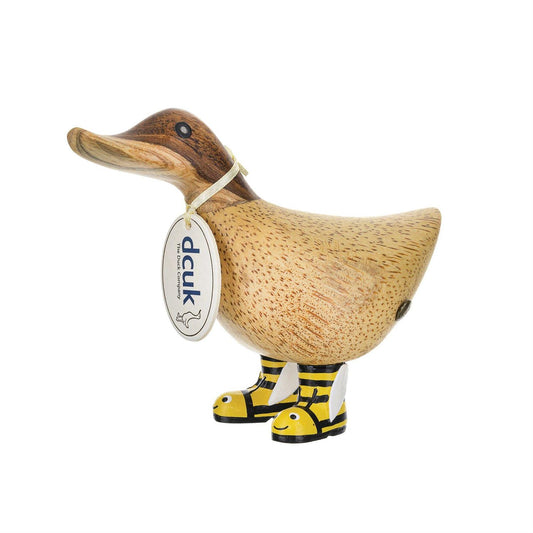 Wooden duck figure with a tag and yellow boots on a white background