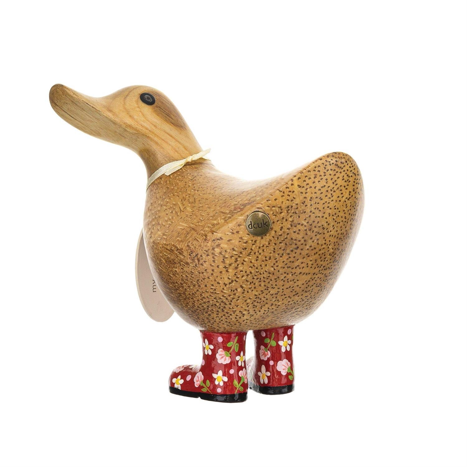 Wooden duck figurine wearing red boots with floral patterns on a white background