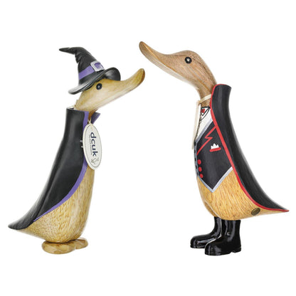 Two wooden duck figurines with a black jackets on a white background