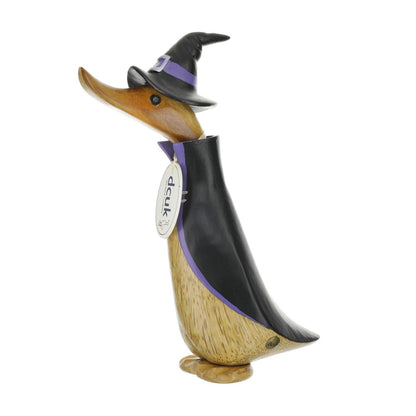 Wooden duck figurine with a black jacket and hat with purple trim on a white background