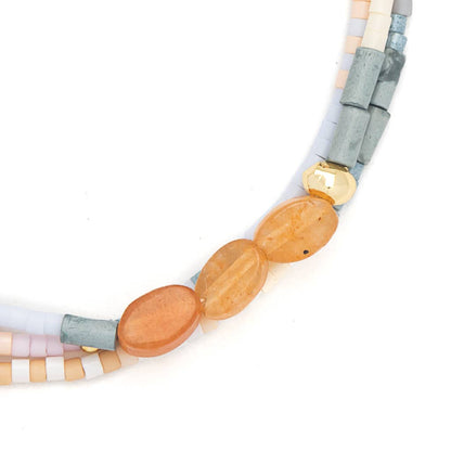 Bracelet with beads and colorful strands on a white background