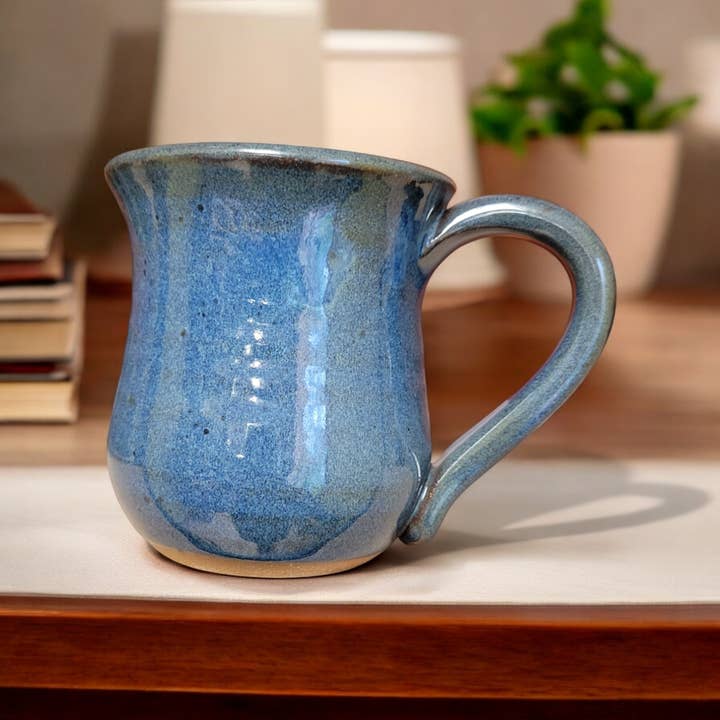 Blue ceramic mug on a wooden surface with a blurred background