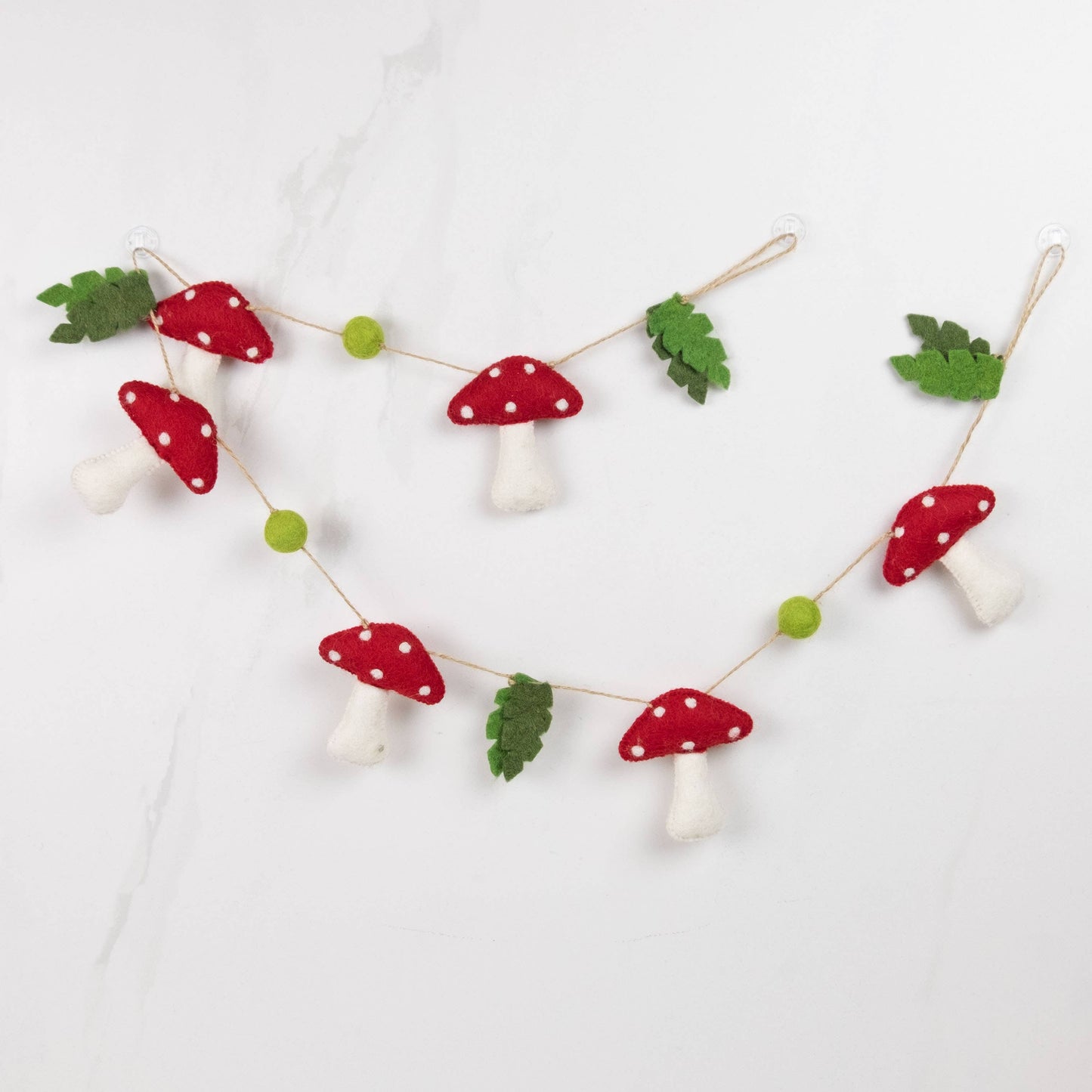 Decorative string with red and white mushroom-shaped ornaments on a light background