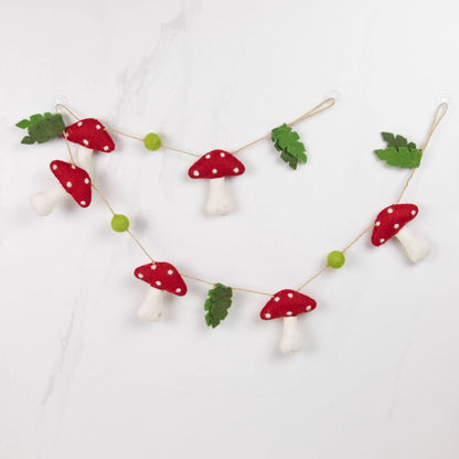 Decorative string with red and white mushroom-shaped ornaments on a light background