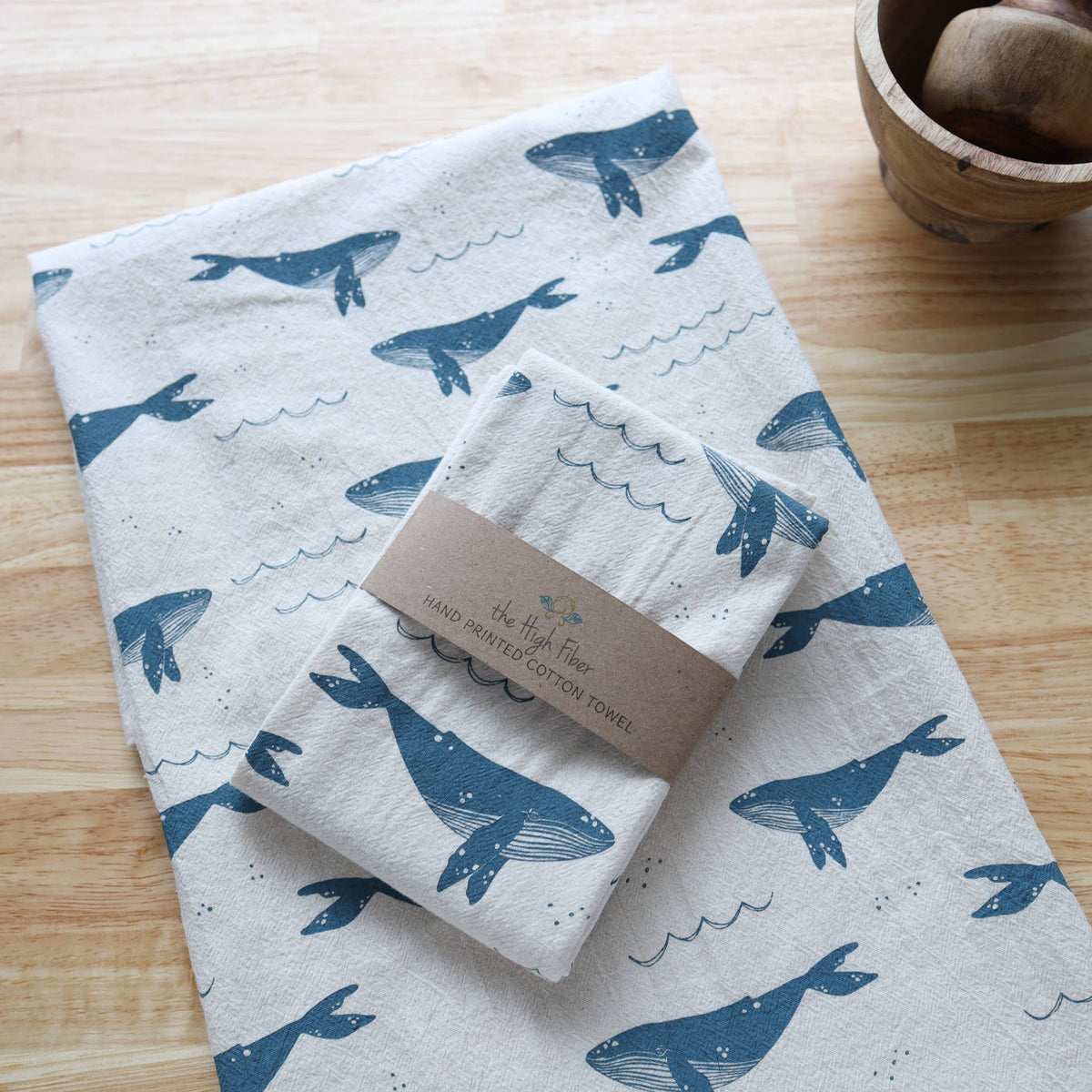 Set of towels with whale pattern on a wooden surface