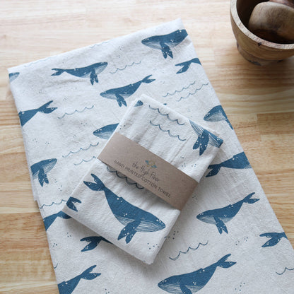 Set of towels with whale pattern on a wooden surface