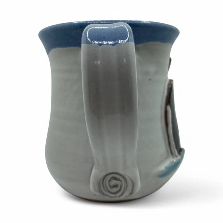 Ceramic mug with a blue rim and handle on a white background