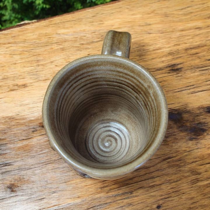 Ceramic mug with spiral design on a wooden surface