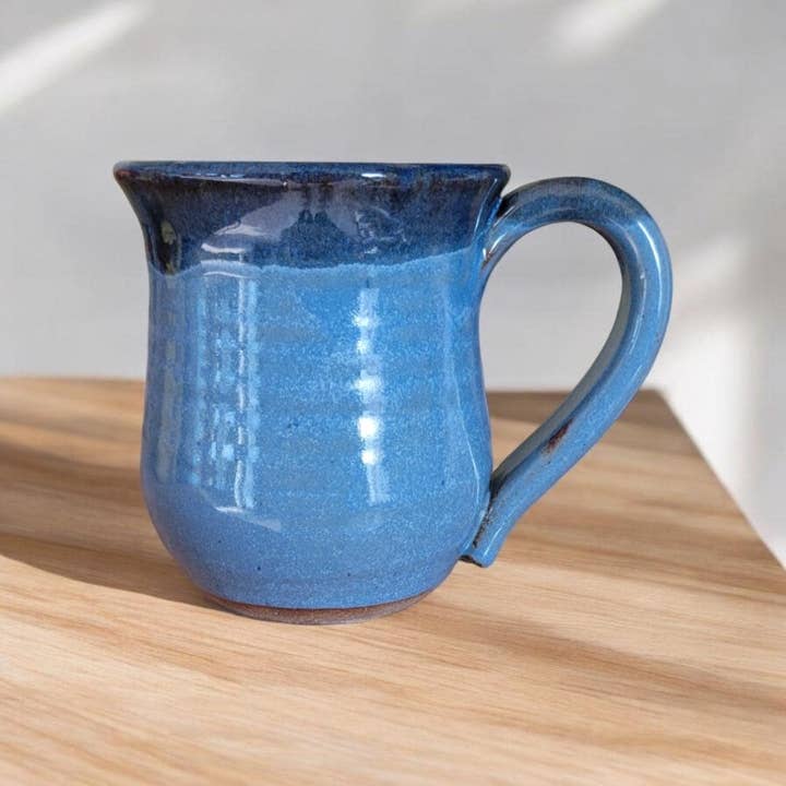 Blue ceramic mug on a wooden surface with a white background