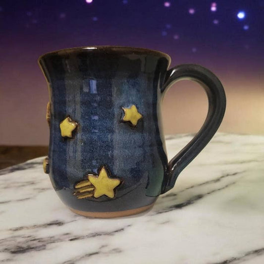 Ceramic mug with star designs on a marble surface