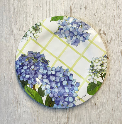 Round decorative plate with blue and white floral design on a wooden surface