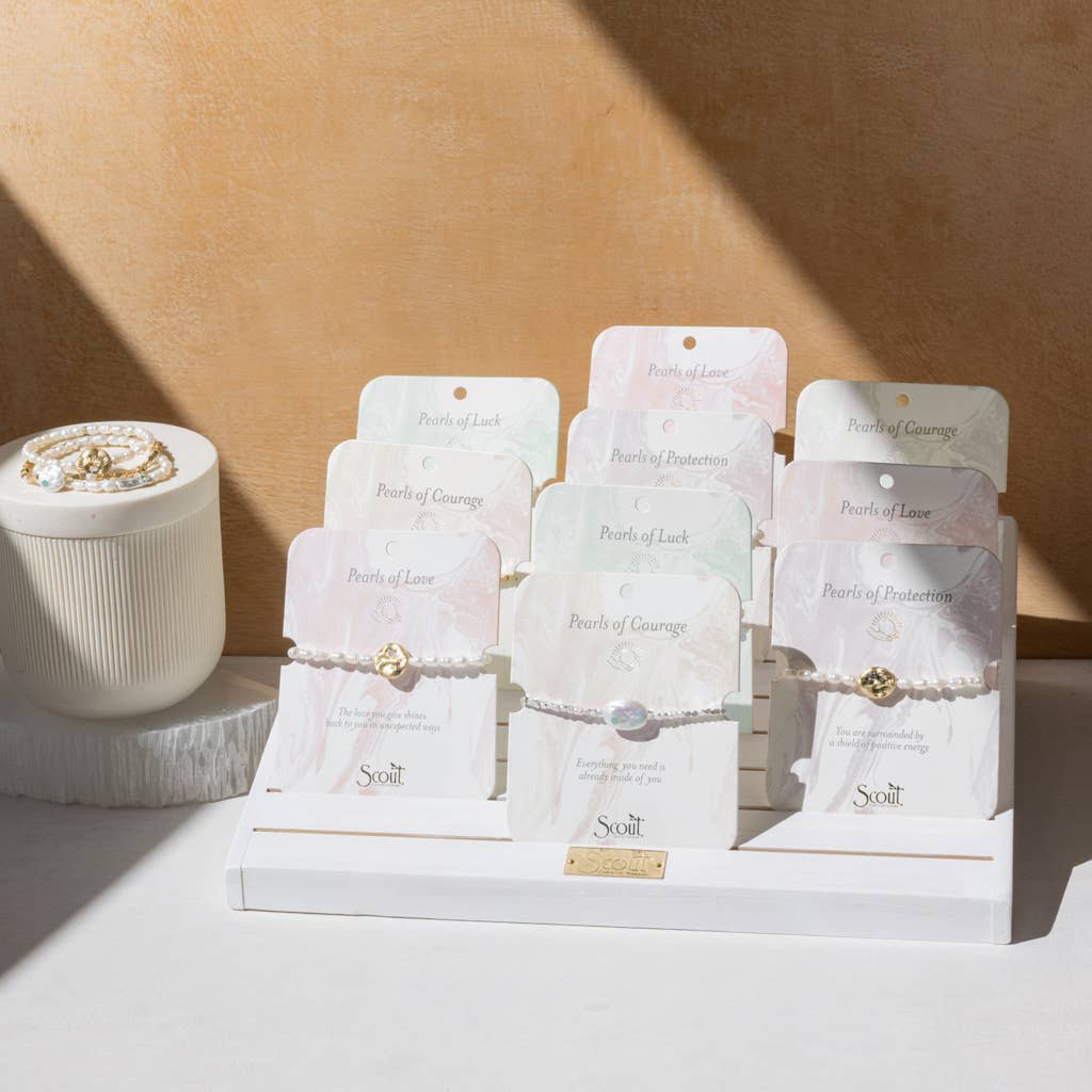 Display of Scout jewelry packaging on a beige background