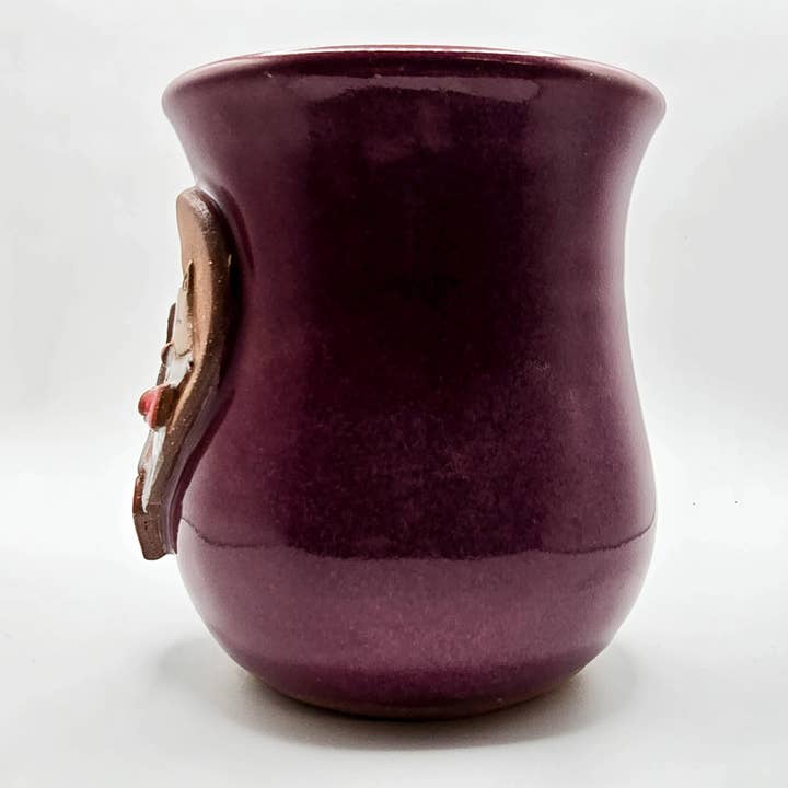 Purple ceramic mug with a decorative handle on a white background