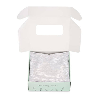 Open product box with eye pillow inside on a white background.