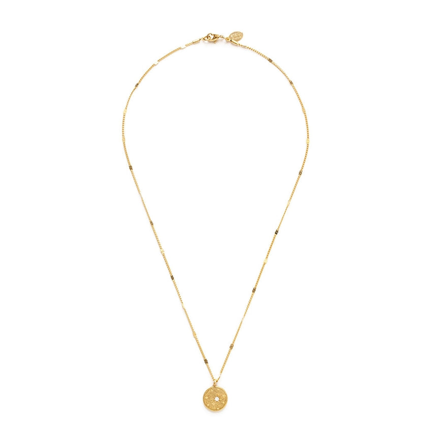 Gold necklace with a round pendant on a white background.
