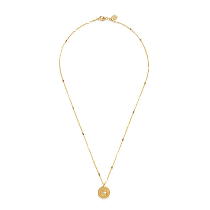 Gold necklace with a round pendant on a white background.