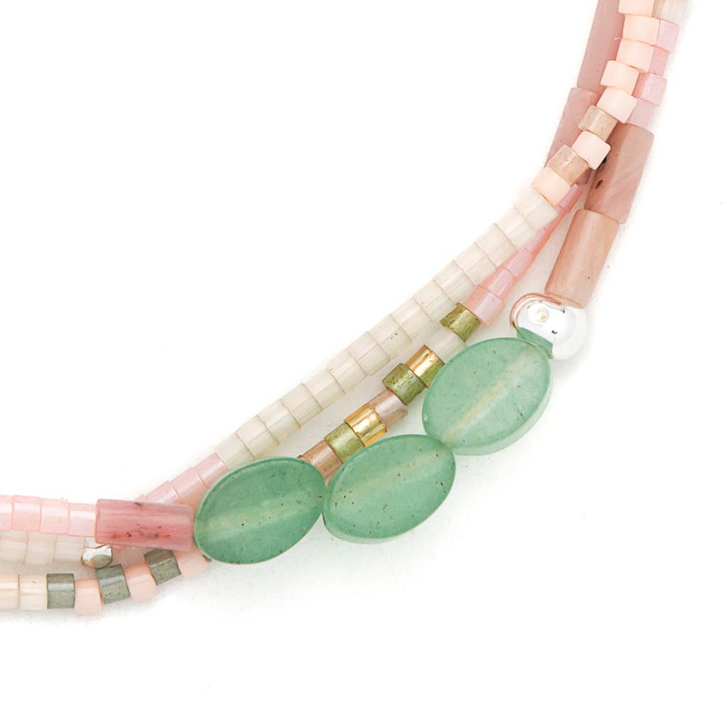 Necklace with pink, green, and gold beads on a white background