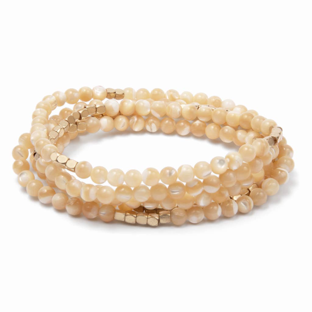 Convertible beige beaded necklace/wrap bracelet on a white background