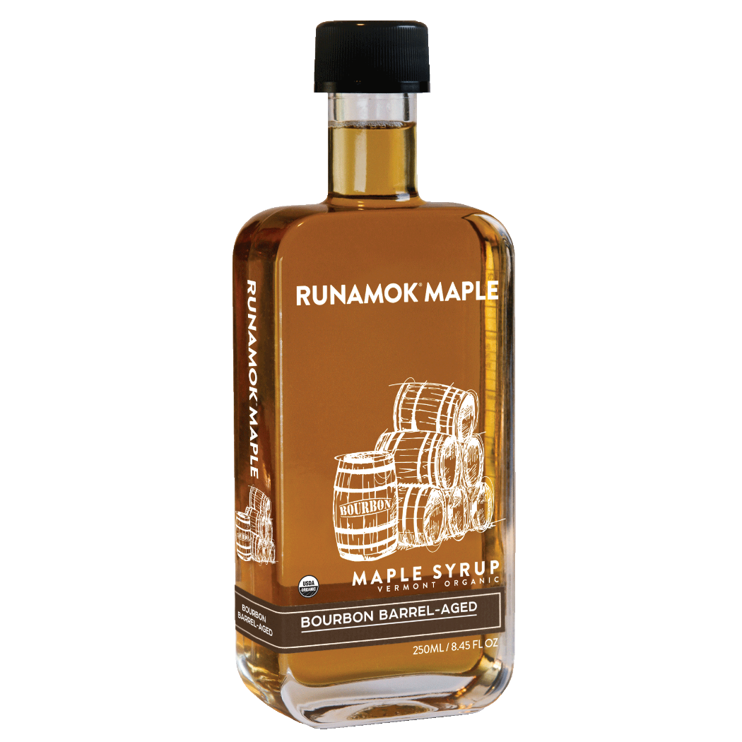 A bottle of Runamok Maple Bourbon Barrel-Aged maple syrup with a black cap and a brown label featuring white barrel illustrations, shown on a plain white background.