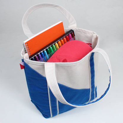 Colorful tote bag with stationery items on a gray background