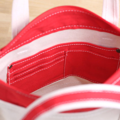 Close-up of a red and white striped fabric with visible stitching.