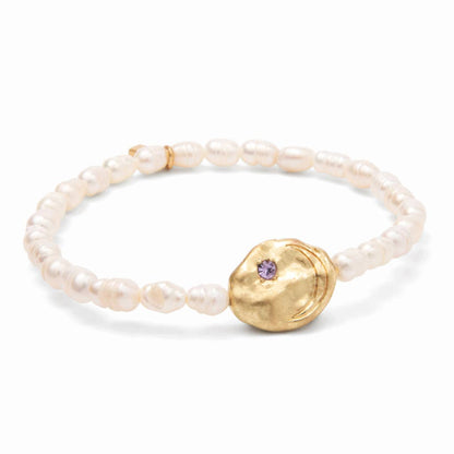 Pearl bracelet with gold disc with purple gemstone on a white background.