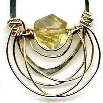 Earring with a large yellow gemstone and gold wirework on a white background