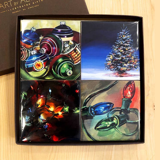 Set of four Christmas-themed coasters in a box on a wooden surface