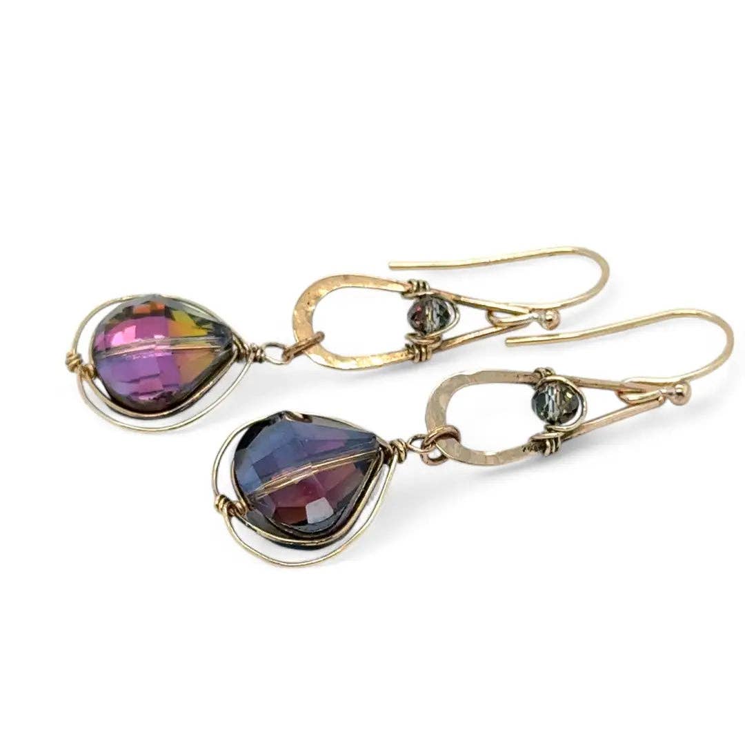 Gold earrings with purple heart-shaped stones on a white background