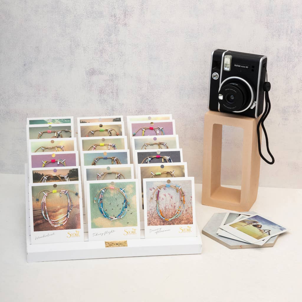 Collection of jewelry cards with a camera on a stand against a gray background
