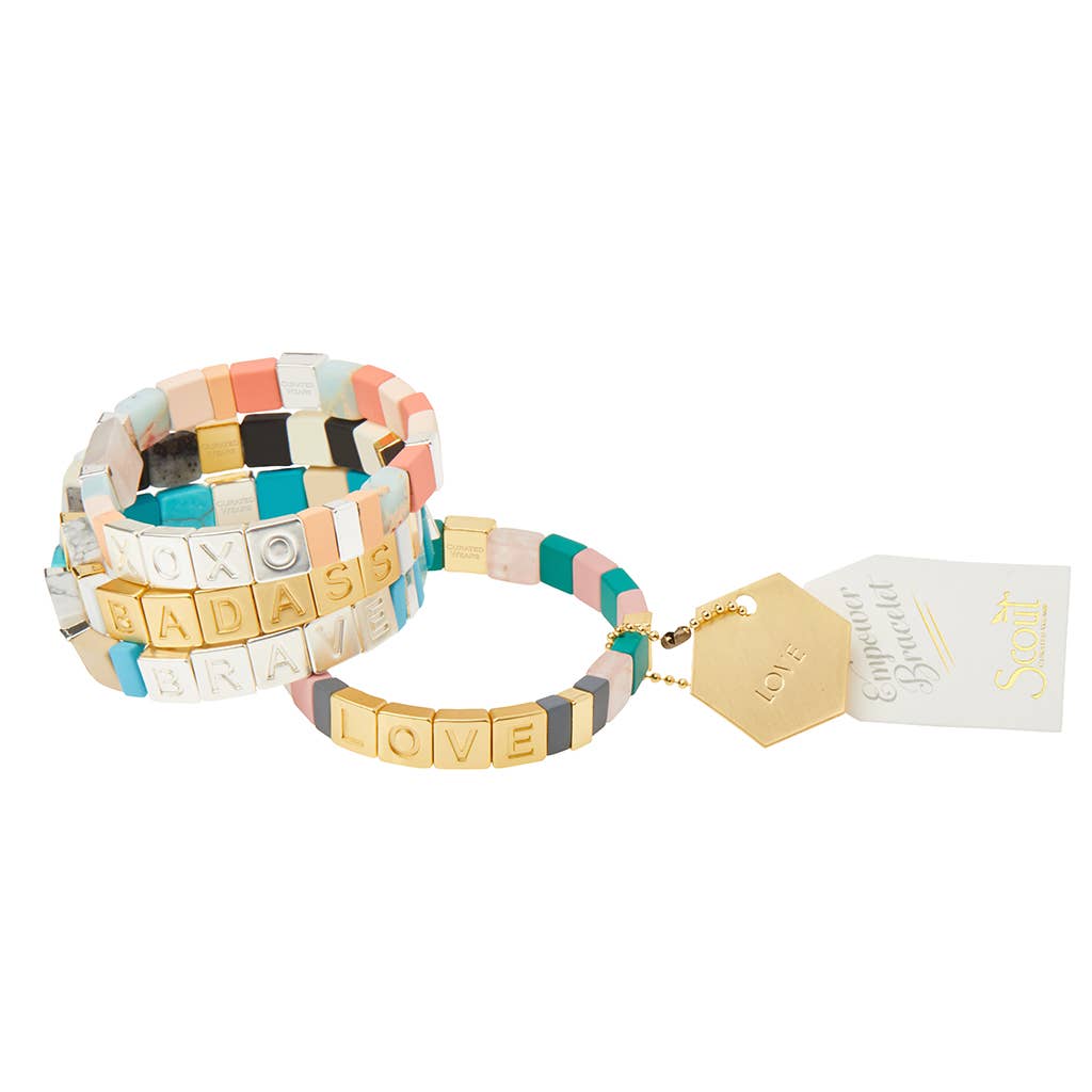 Set of colorful bracelets with letter beads on a white background