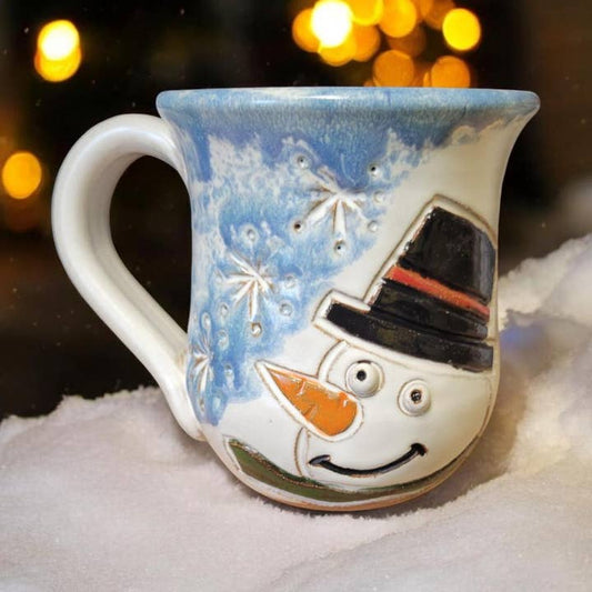 Ceramic mug with a snowman design on a snowy background
