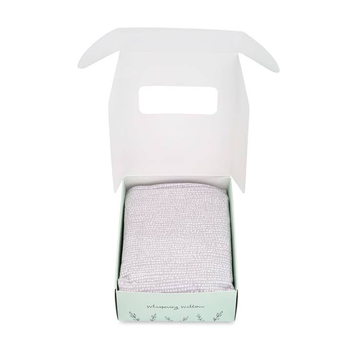 Lavender neck wrap in a green and white box on a white background