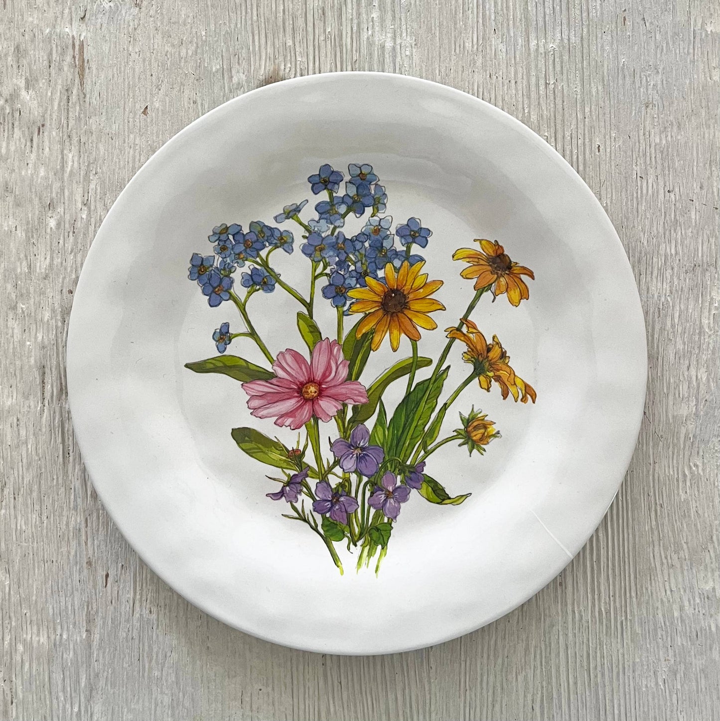 White plate with a floral design on a wooden surface