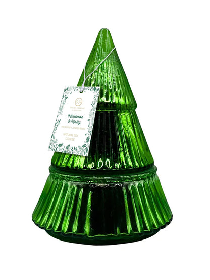 Green glass Christmas tree-shaped candle with a label on a white background