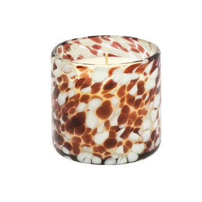 Candle in a glass container with a marbled pattern on a white background