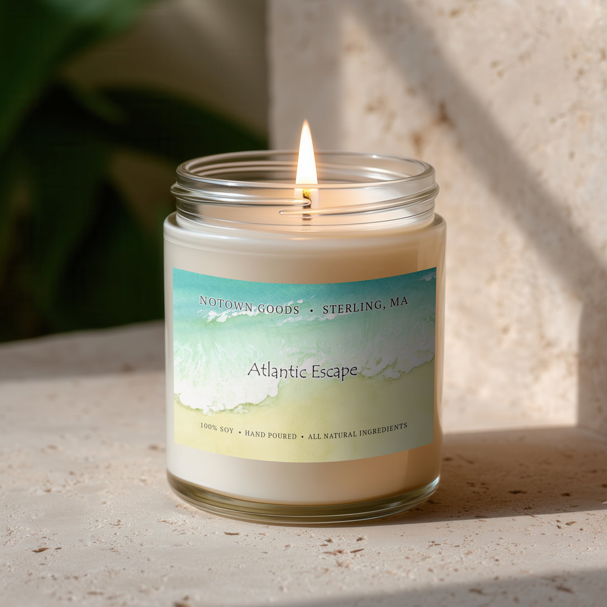 Clear jar candle with white wax and a decorative label on a textured outdoor background.